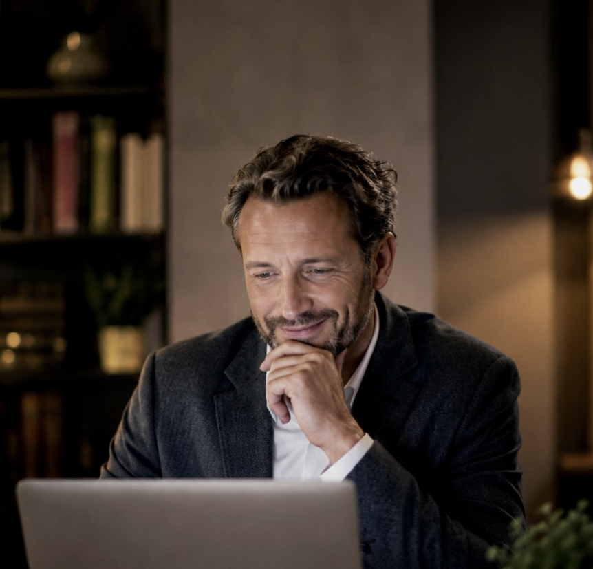 Leidinggevende achter zijn laptop, glimlachend terwijl hij de uitkomst van een instrument doorneemt.
